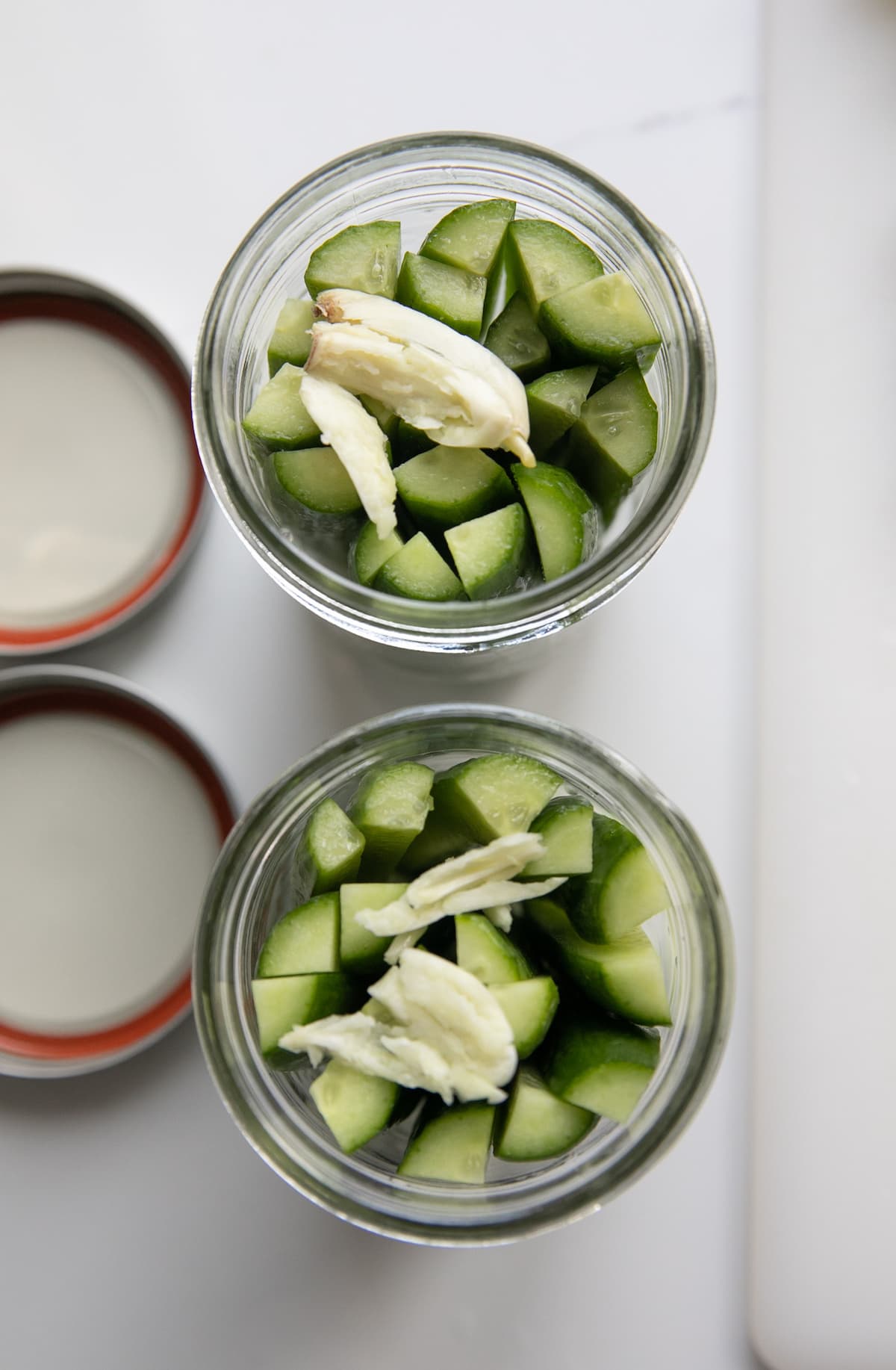 cut cucumbers in jars with garlic cloves