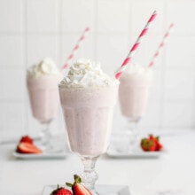 strawberry milkshakes in a glass with straw