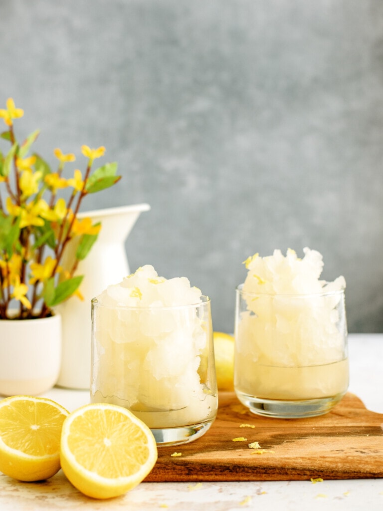 2 glasses of frozen lemonade on counter with lemons