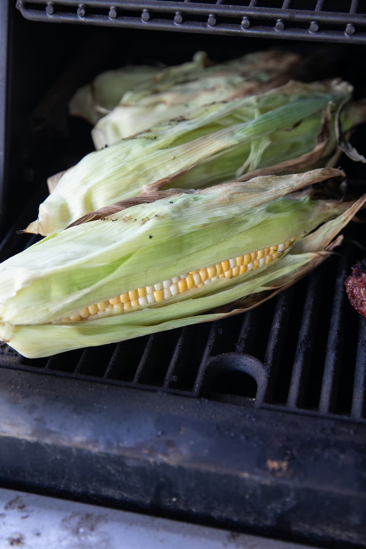 grilling corn on bbq in husk