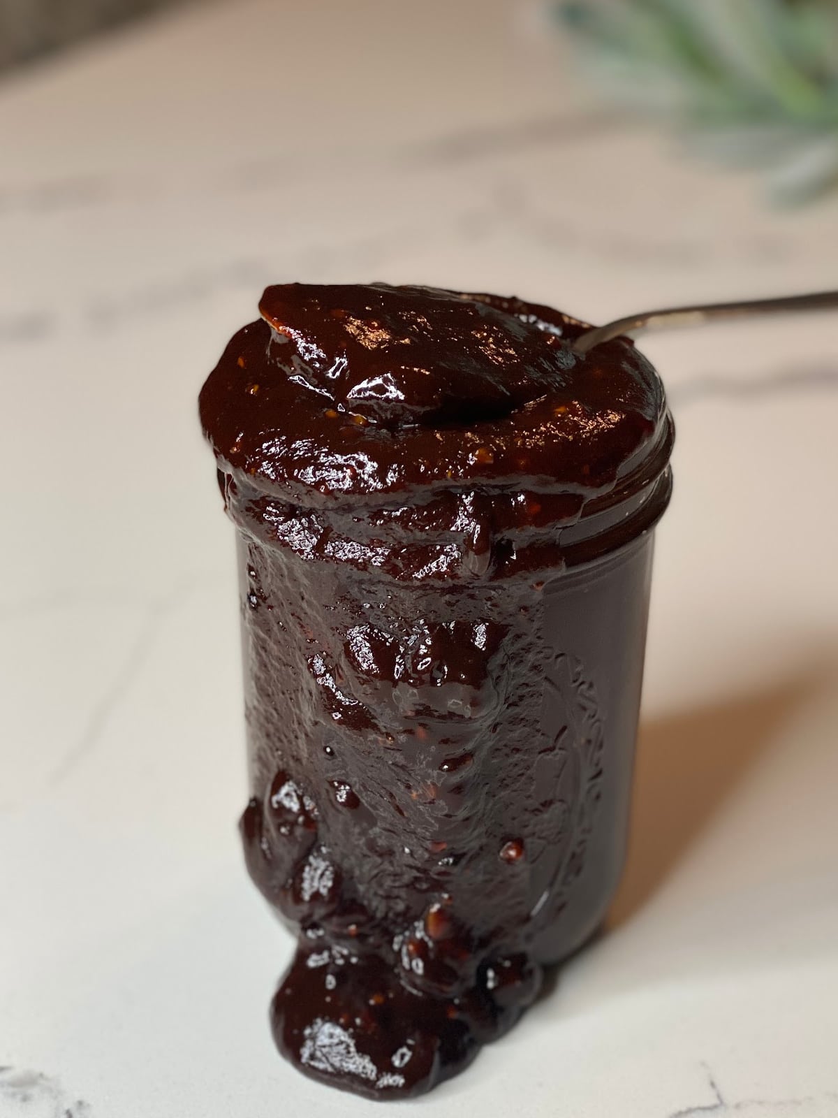 Homemade BBQ Sauce dripping out of jar with spoon