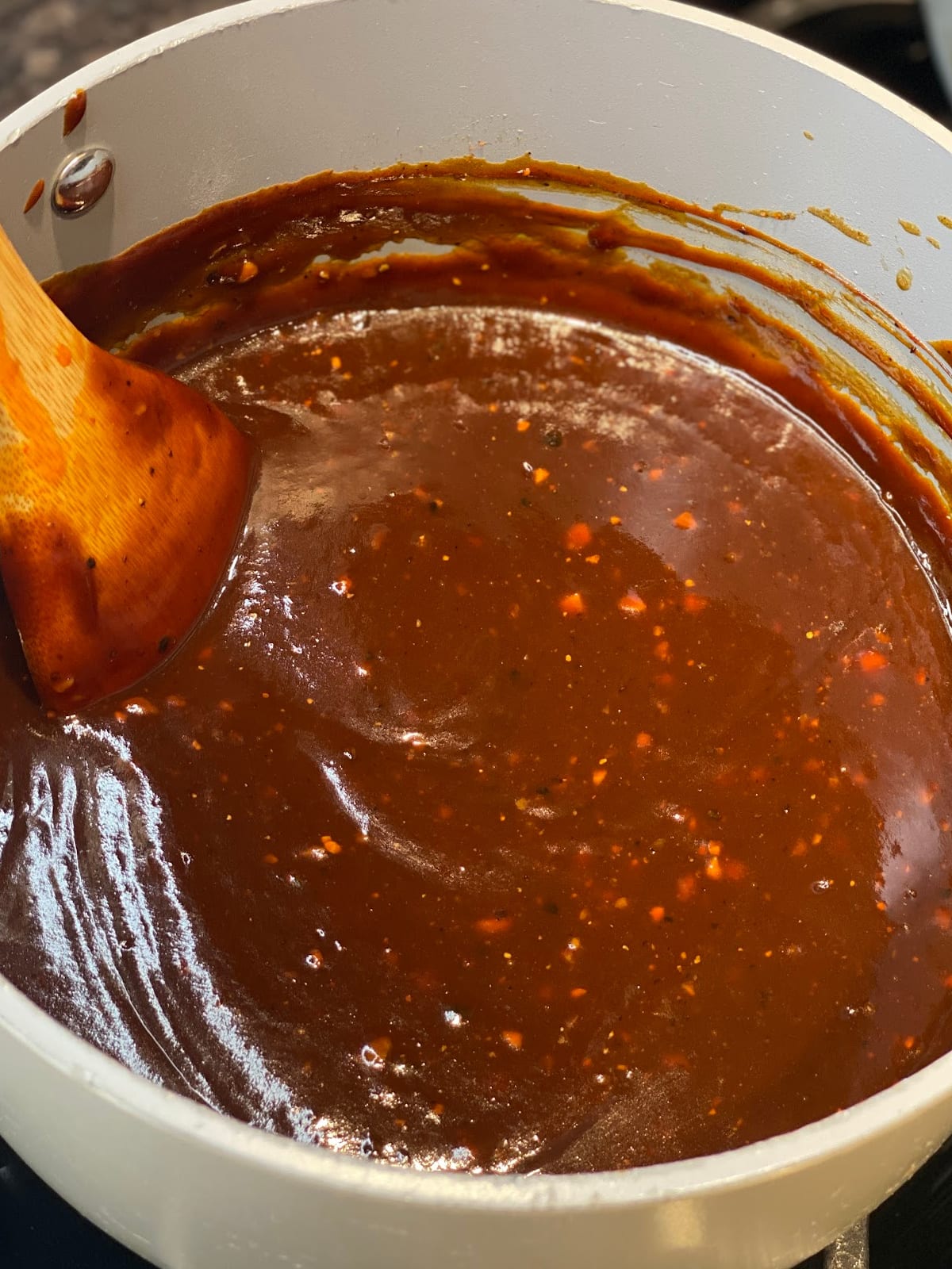 Homemade BBQ Sauce cooking in pan with spoon