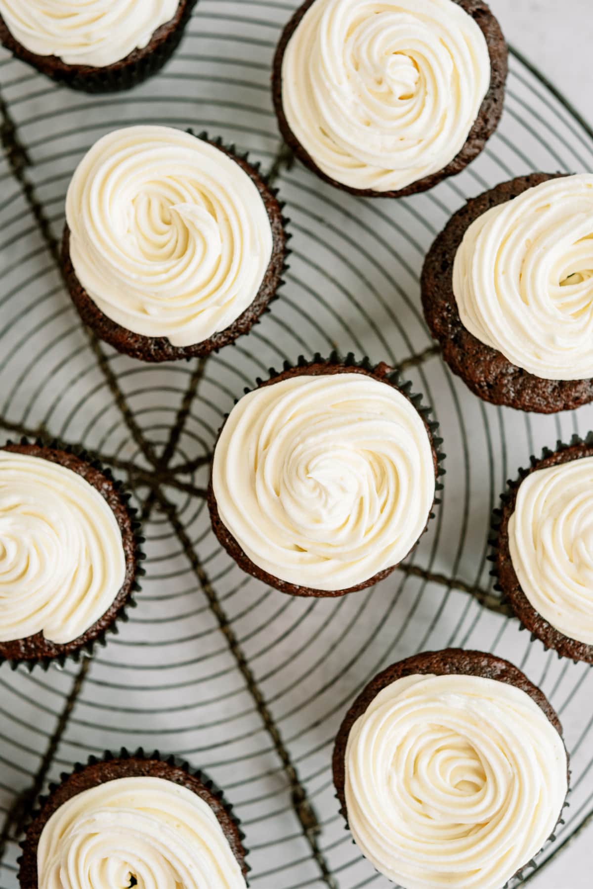 chocolate-cupcakes-with-vanilla-frosting on round wire rack