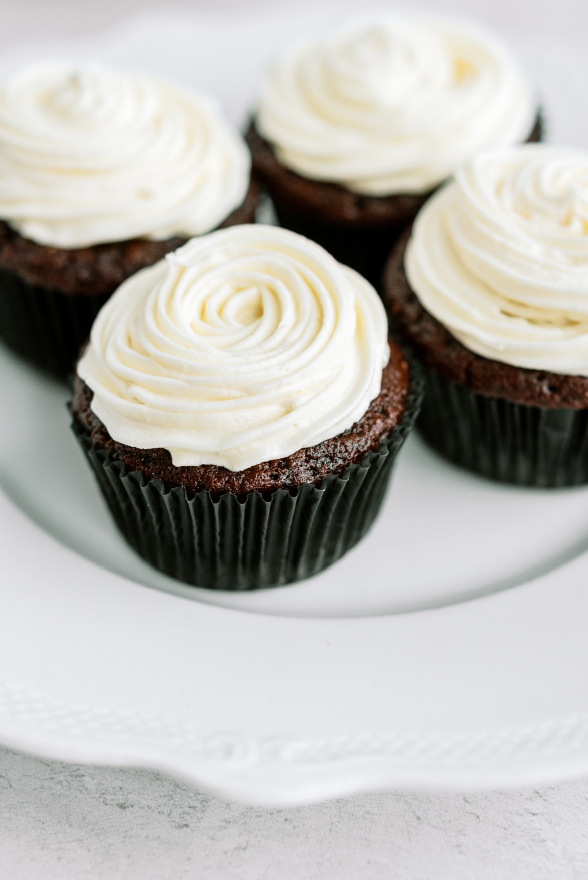 chocolate-cupcakes-with-vanilla-frosting on white plate