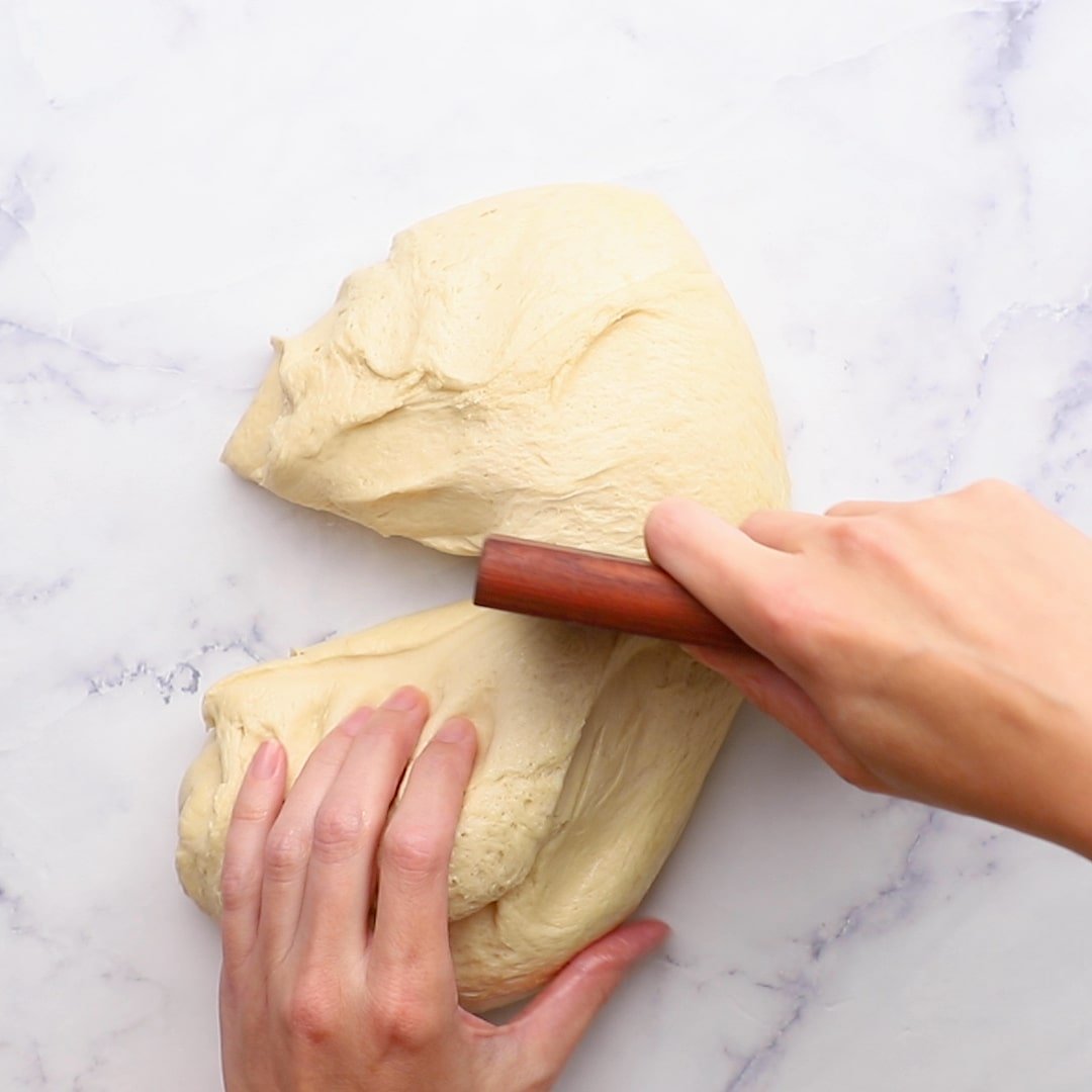 cutting dinner roll dough in half