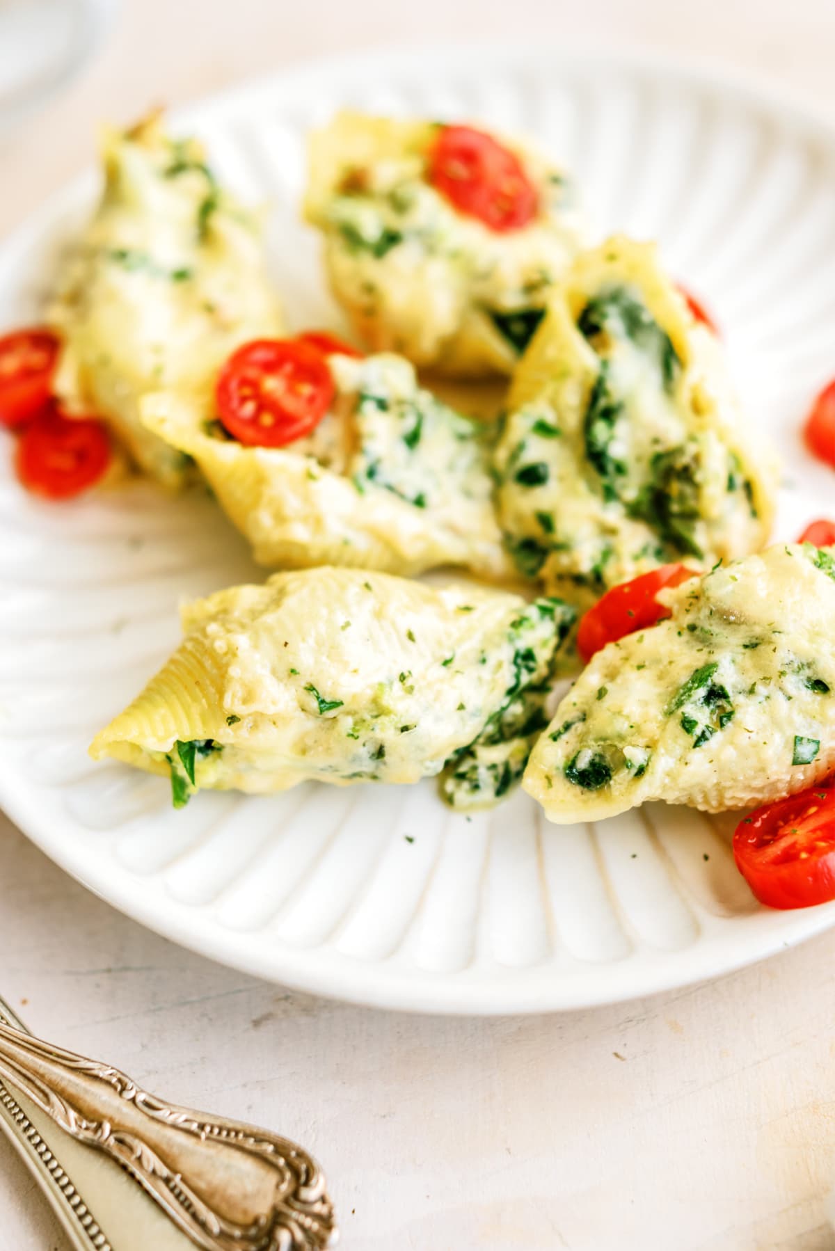 Chicken Alfredo Stuffed Shells on plate with tomatoes
