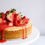 strawberry-cheesecake on stand with strawberry sauce dripping