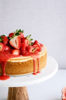 strawberry-cheesecake on stand with strawberry sauce dripping