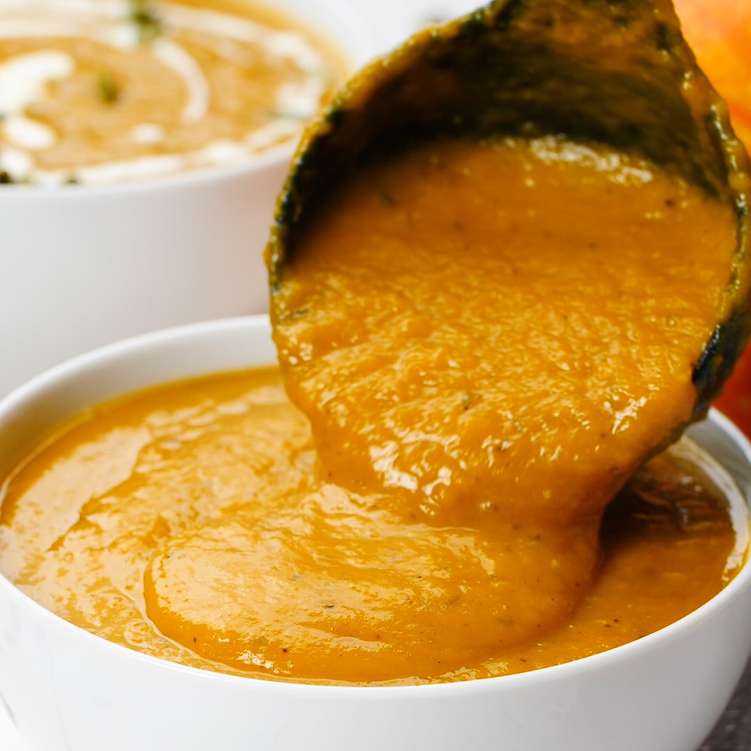 pouring pumpkin soup in bowl