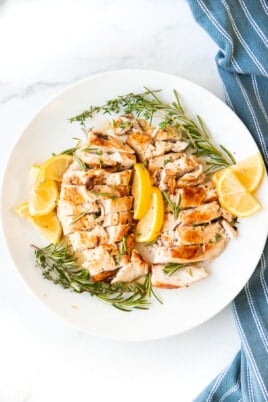 Sous Vide Chicken on plate with lemons and herbs