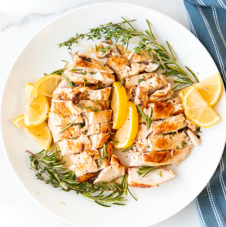 Sous Vide Chicken on plate with lemons and herbs