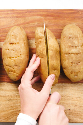slicing open baked potatoes