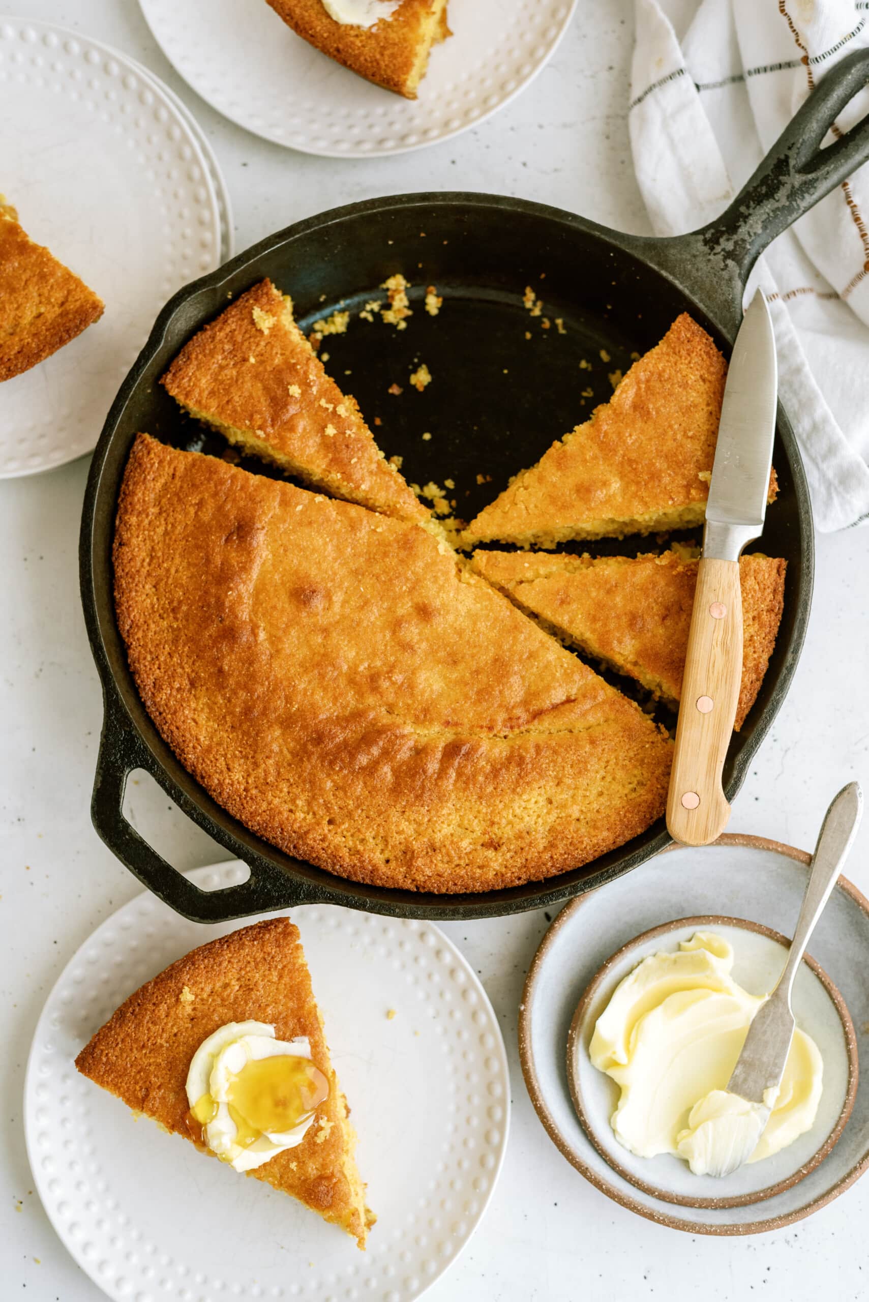 Cornbread in cast iron skillet and serving plate