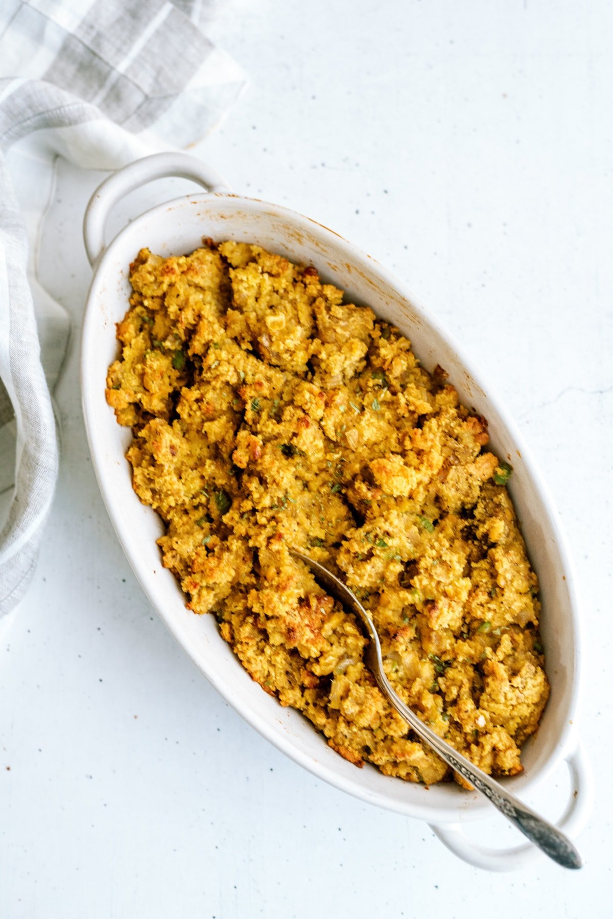 cornbread stuffing in dish with serving spoon