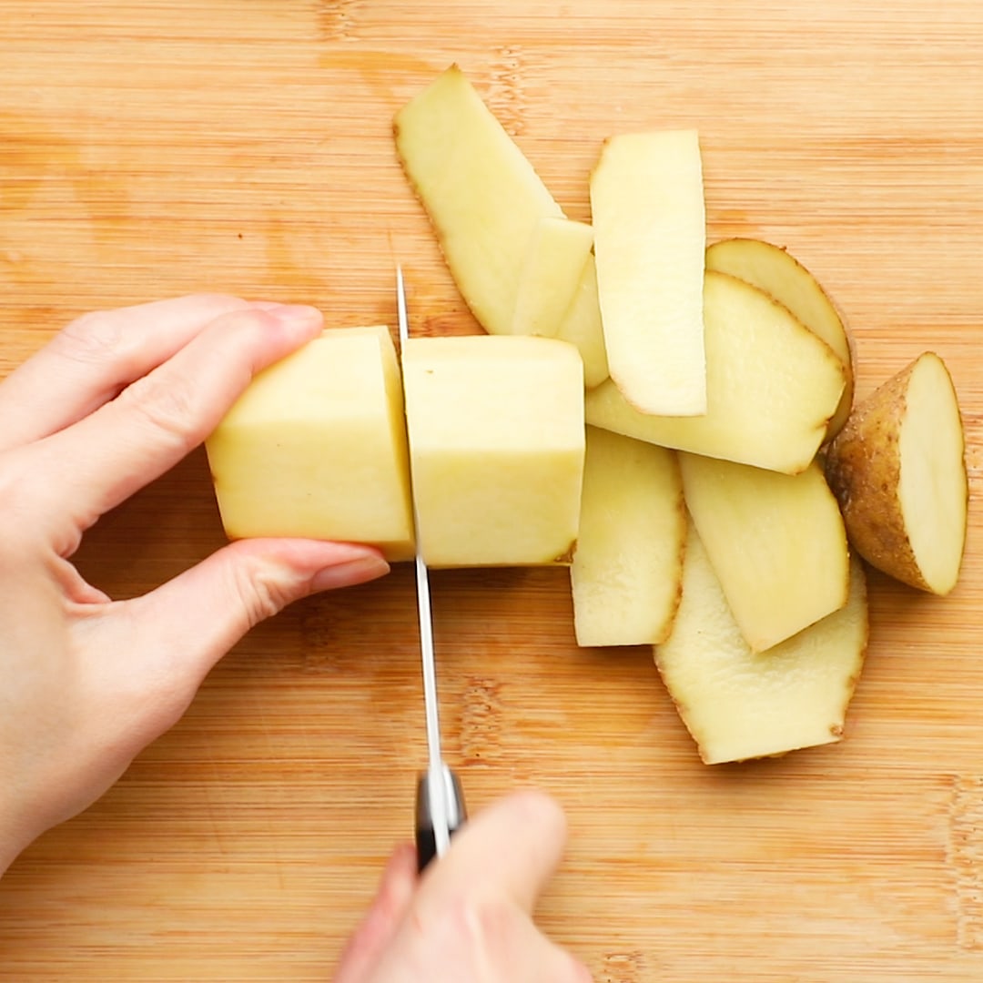 woman's hand cutting potatoes