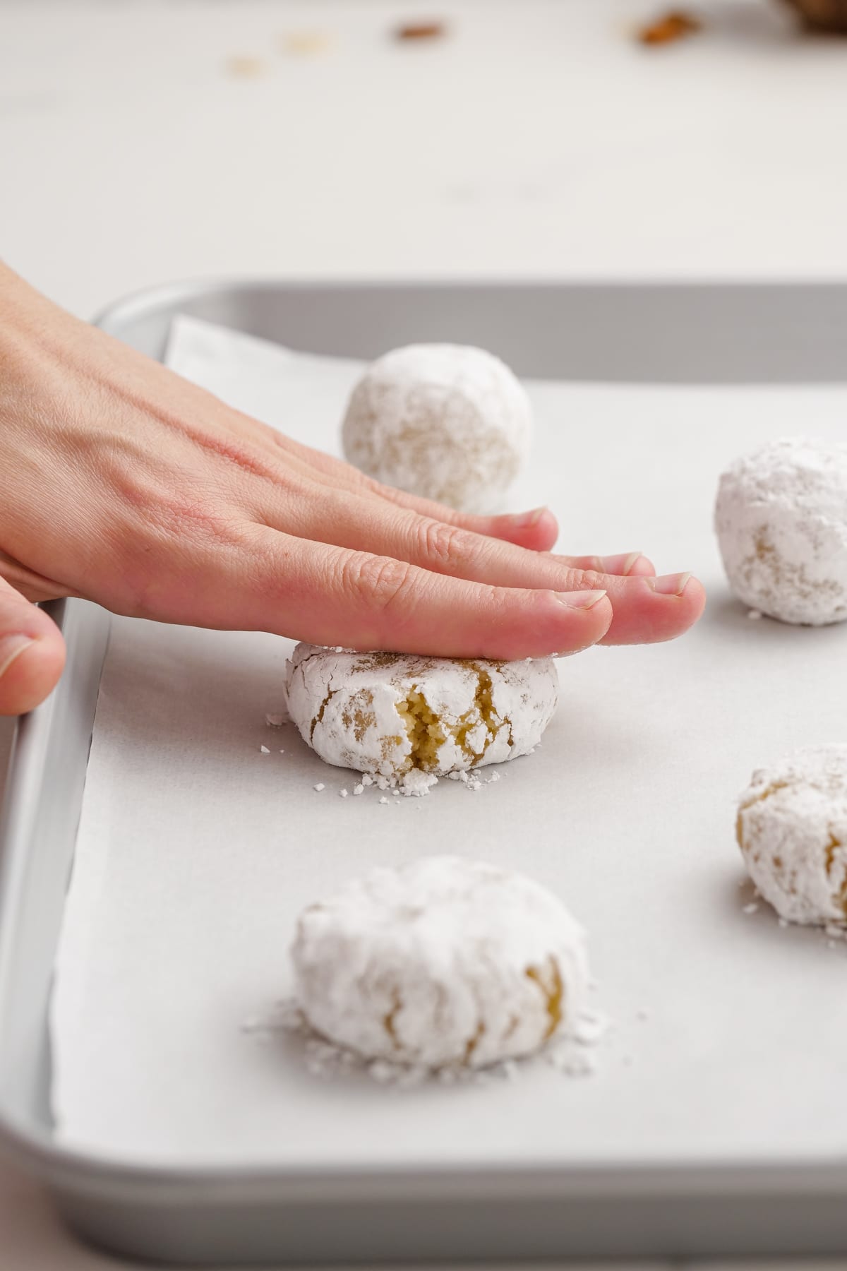 woman pressing down amaretti cookies with fingers