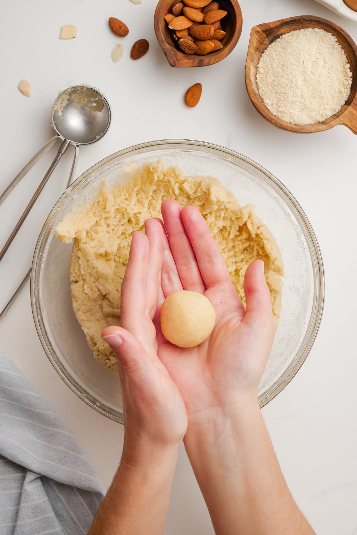 amaretti cookies dough, woman's hands rolling into ball