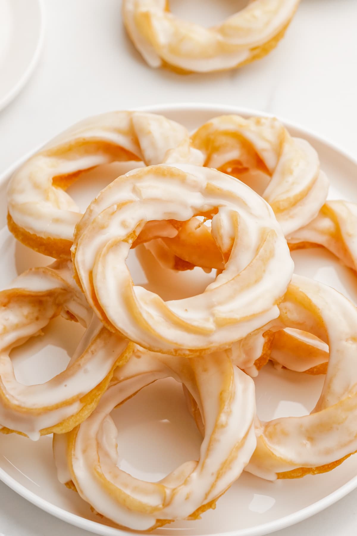 pile of french crullers on plate