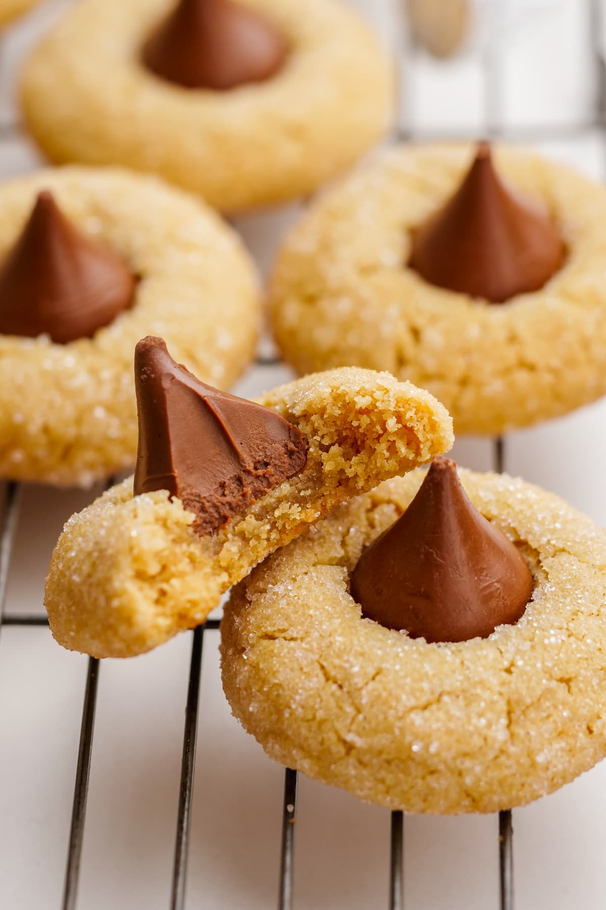 peanut butter blossoms on cooling rack with bite taken out