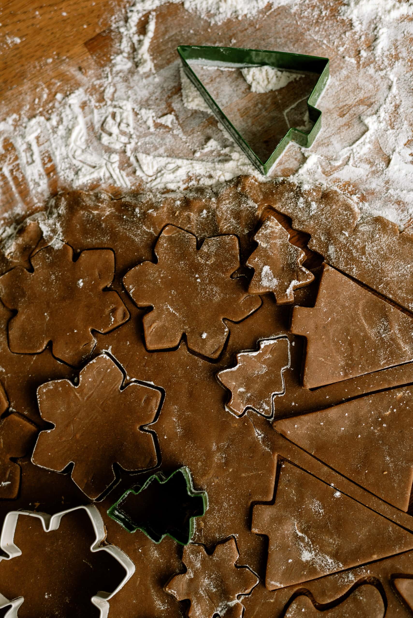 uncooked gingerbread dough cut with cookie cutter shapes