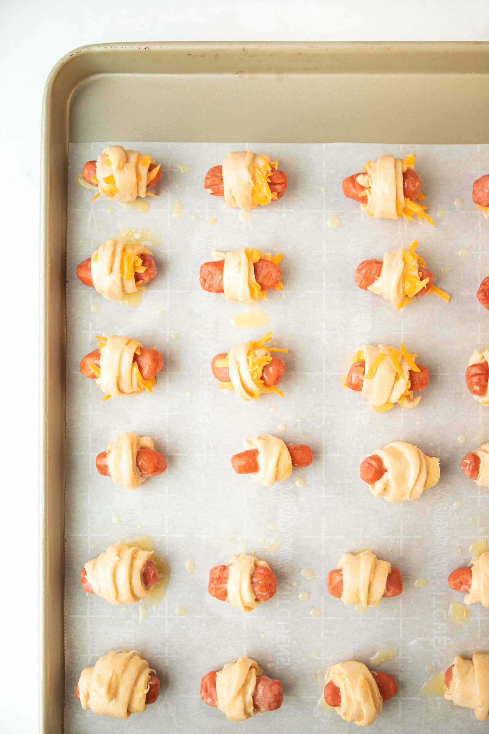 unbaked pigs in a blanket on baking sheet