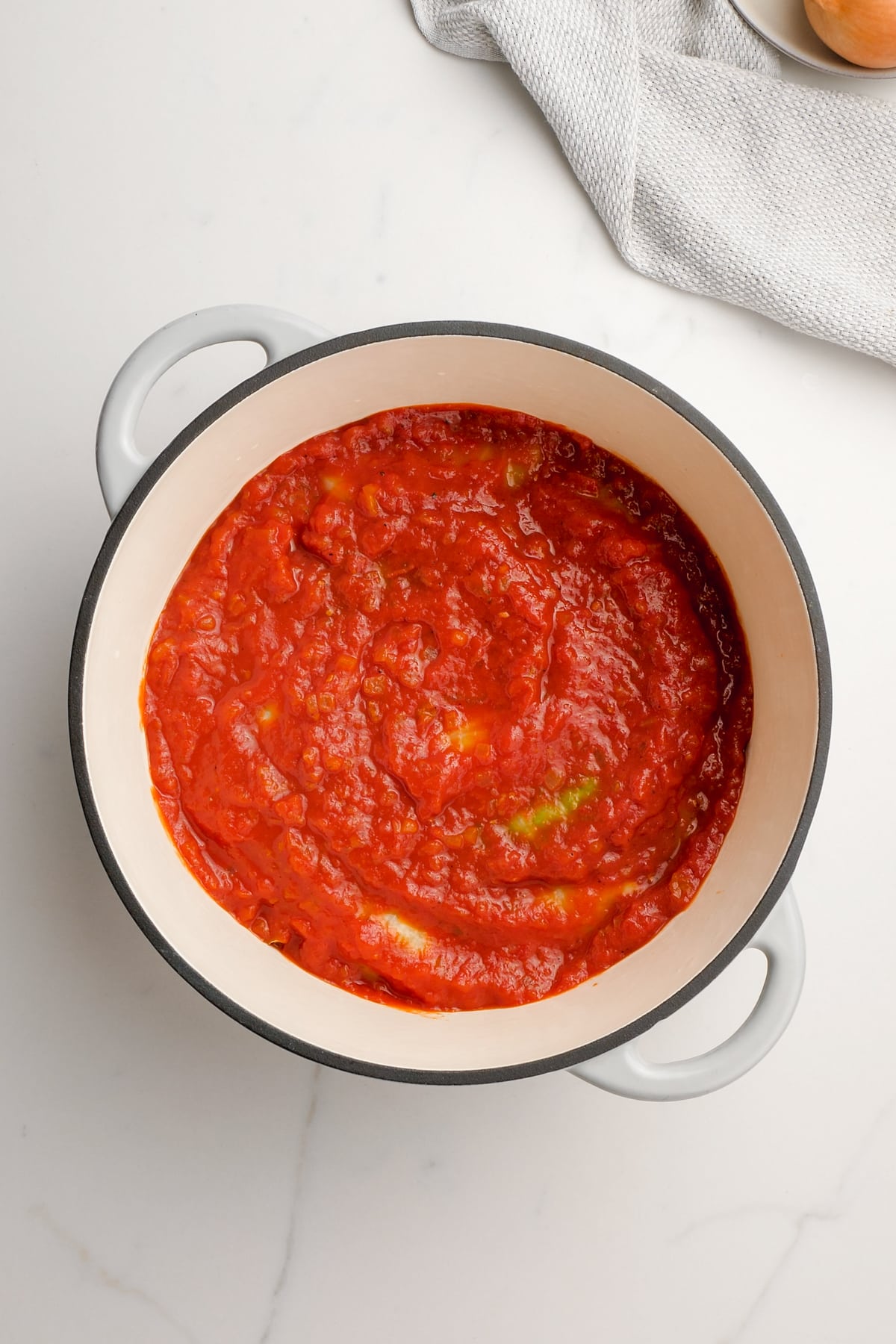 tomato sauce overtop cabbage rolls in dutch oven