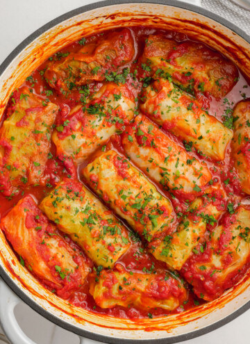 cooked cabbage rolls in dutch oven with fresh parsley