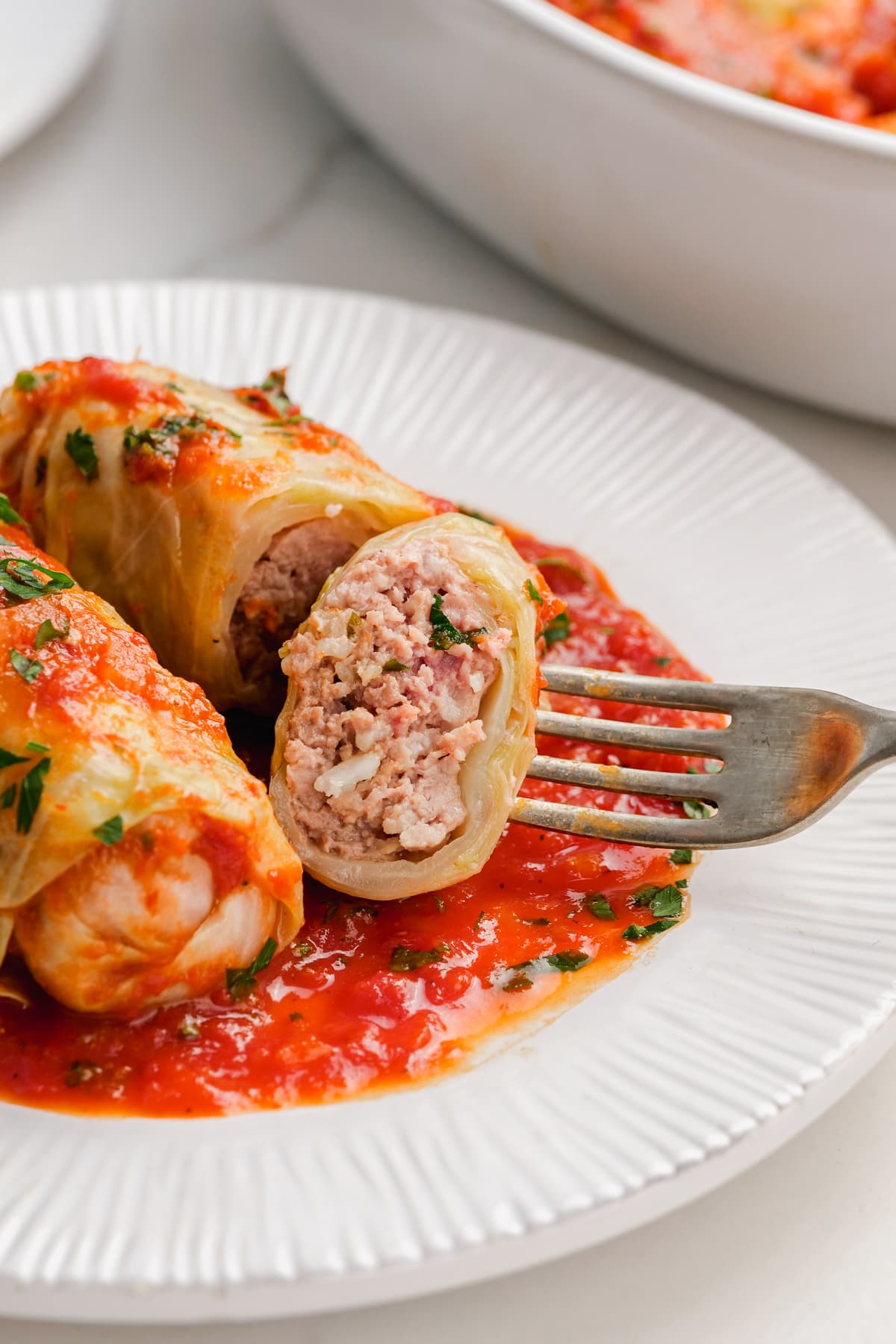 plated cabbage rolls with fork cutting into middle