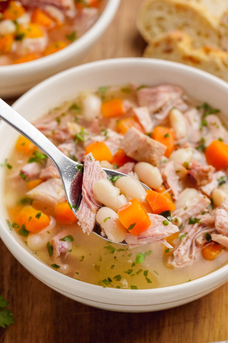 spooning out ham and bean soup from bowl