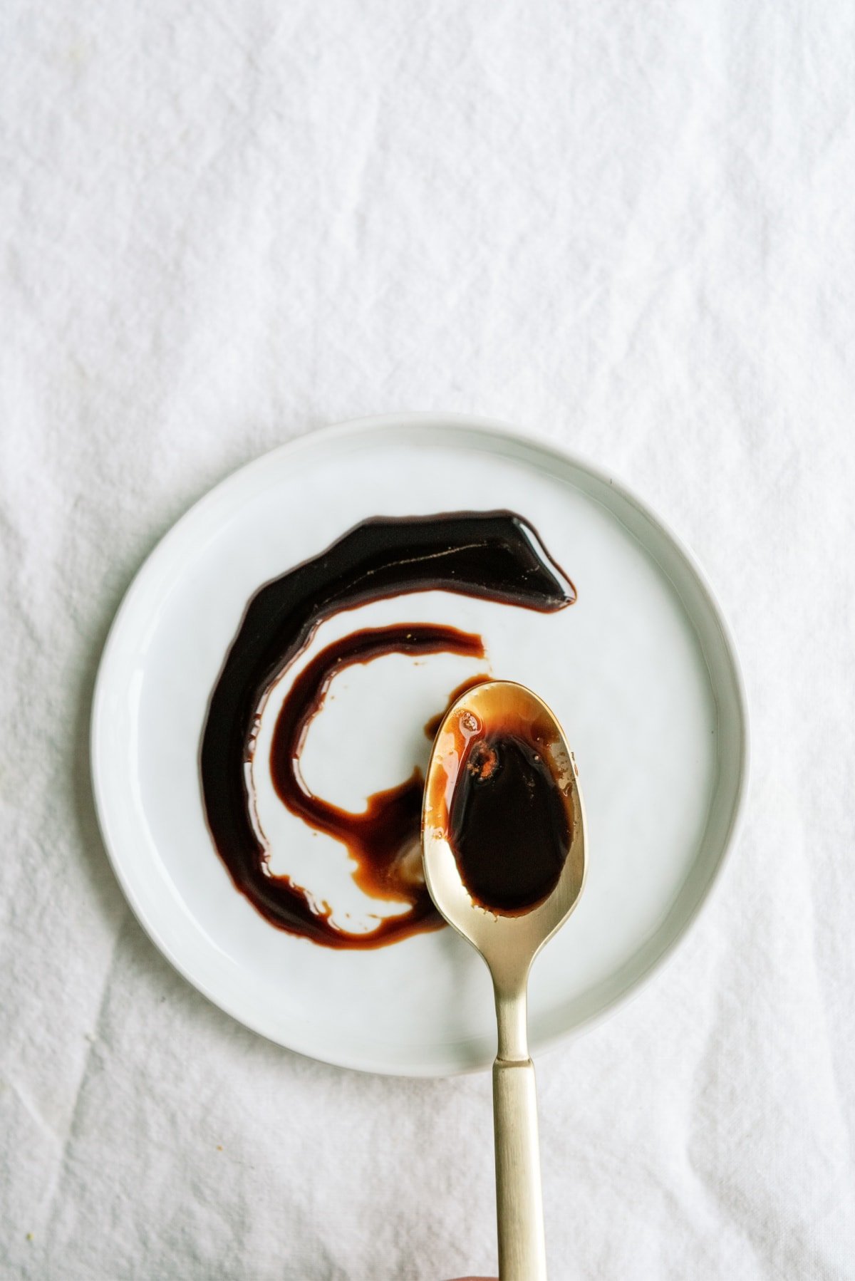 balsamic reduction swirled on plate with spoon