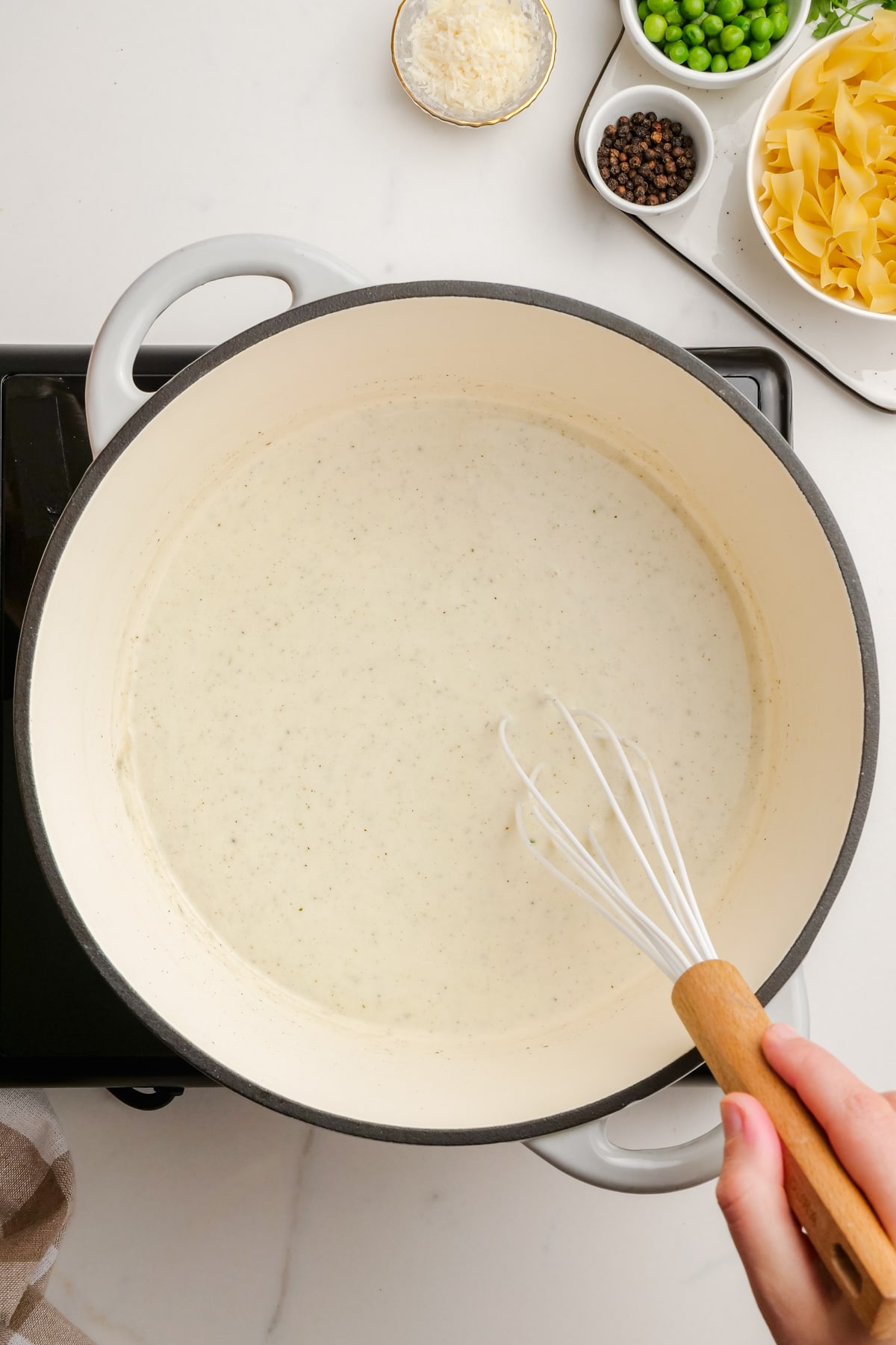 woman's hand whisking milk in saucepan