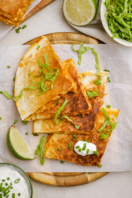 chicken quesadilla triangles with shredded lettuce and lime wedge