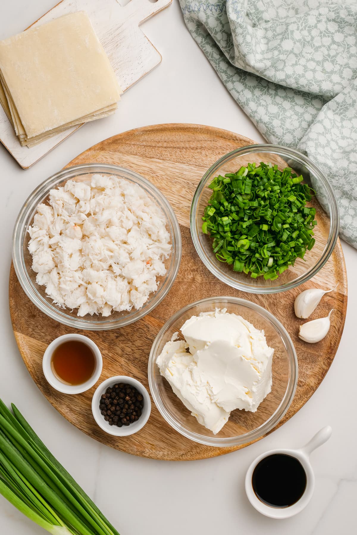 ingredients for crab rangoon in bowls- crab meat, green onions, soy sauce, sesame oil, garlic and cream cheese 