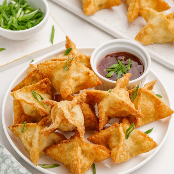 crab rangoon on a plate with dipping sauce