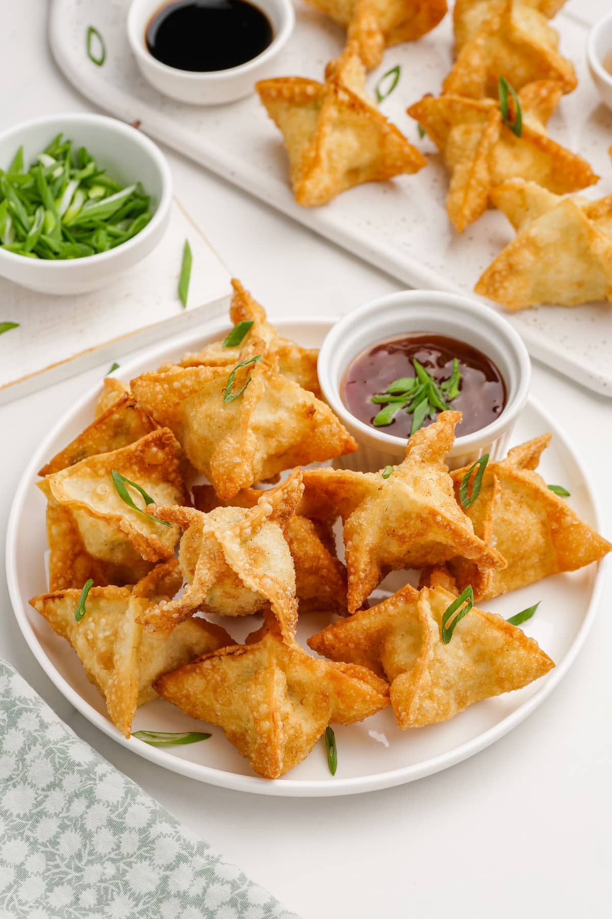 crab rangoon on a plate with dipping sauce