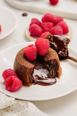 molten-lava-cake with raspberries on plates with spooned out filling