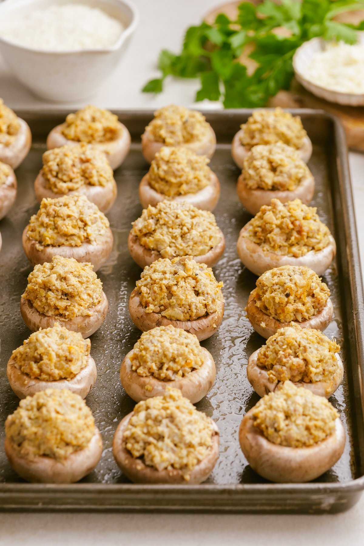 uncooked sausage-stuffed-mushrooms on baking sheet