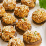 cooked sausage-stuffed-mushrooms on parchment paper