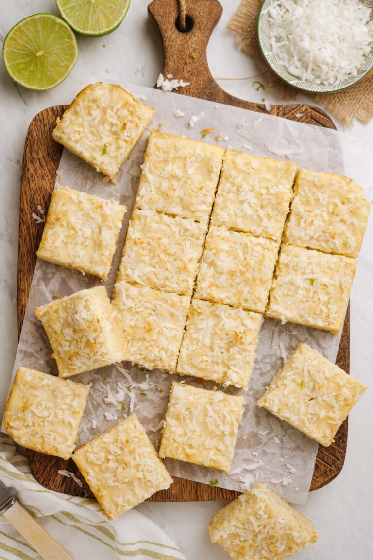 cut coconut-bars on cutting board with parchment paper