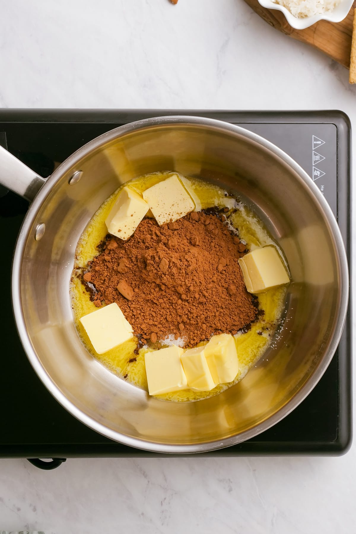 butter cubes and cocoa powder in a pan on the stove
