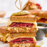 halves of reuben sandwich stacked with toothpick to secure