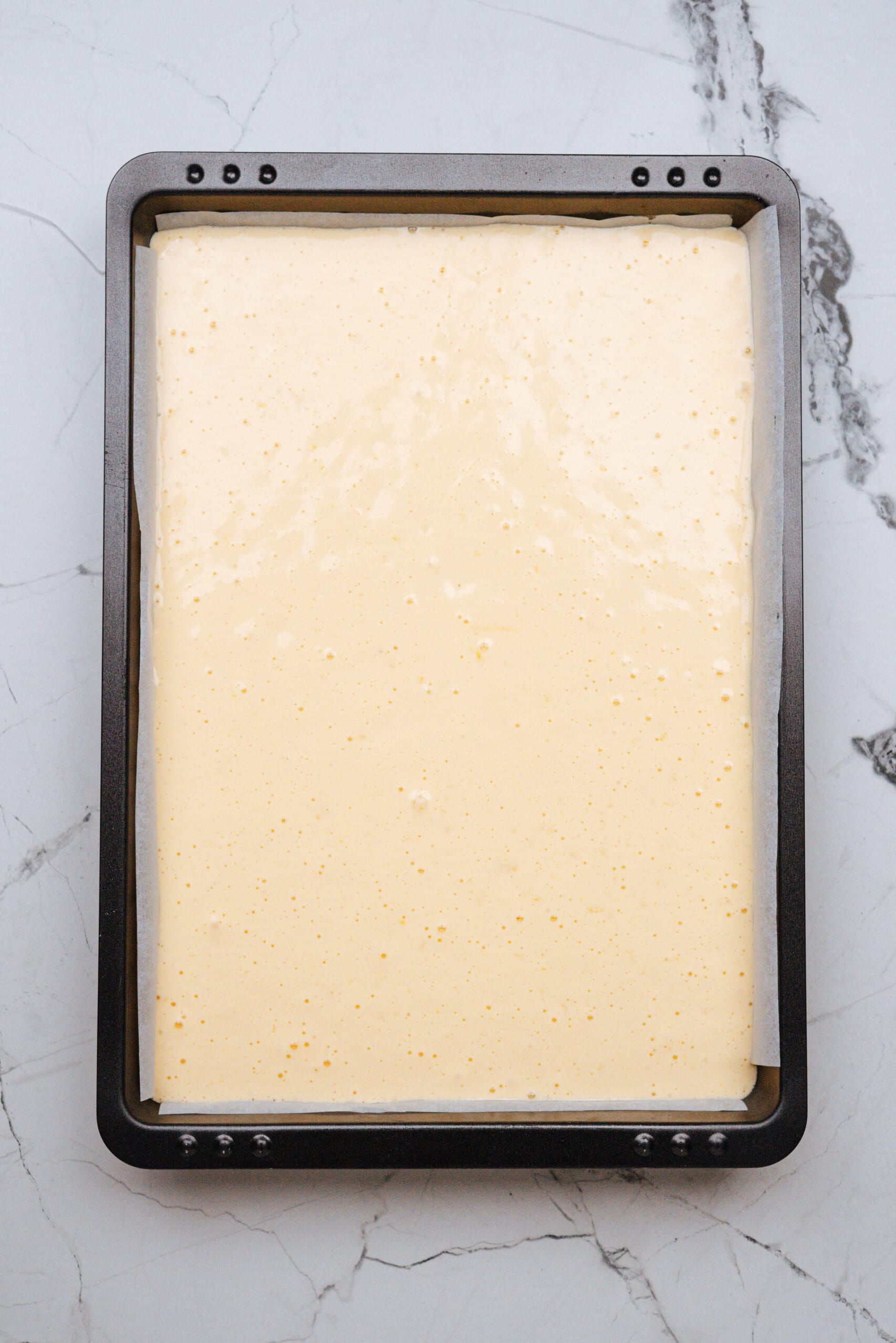 pistachio lemon roll cake batter in a baking pan uncooked