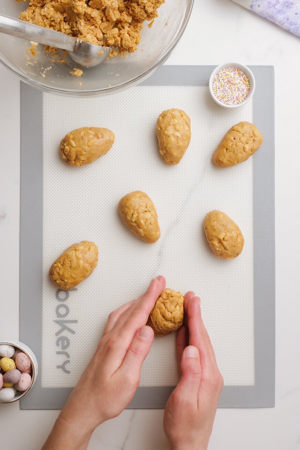 woman's hand forming peanut-butter-easter-eggs-on mat