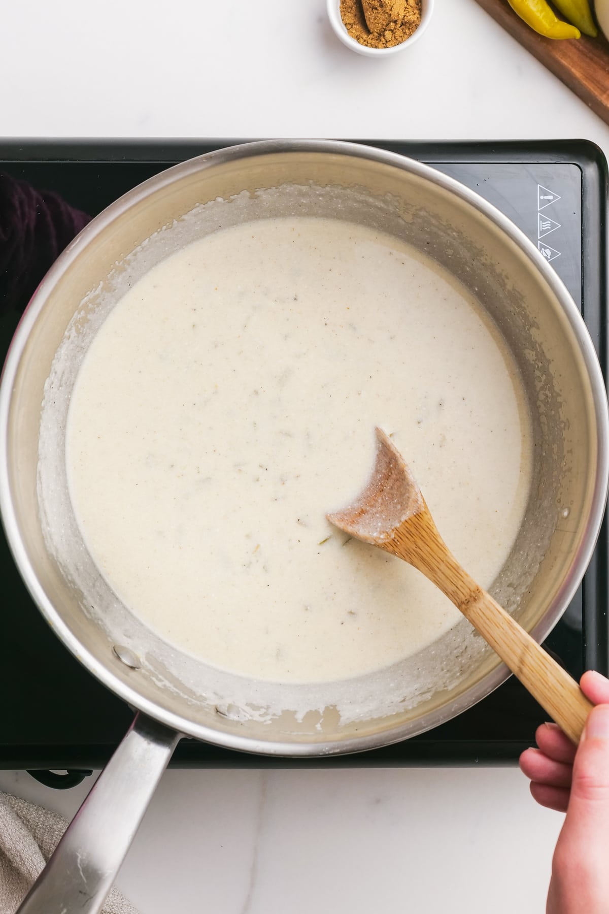 sour cream enchilada sauce in a pot with a wooden spoon