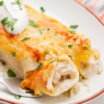 sour cream enchiladas on a plate with dollop of sour cream