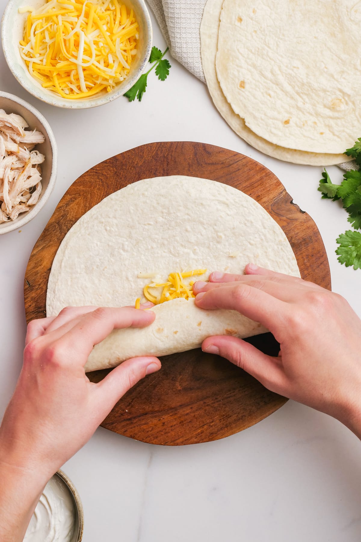 woman's hands rolling tortilla up