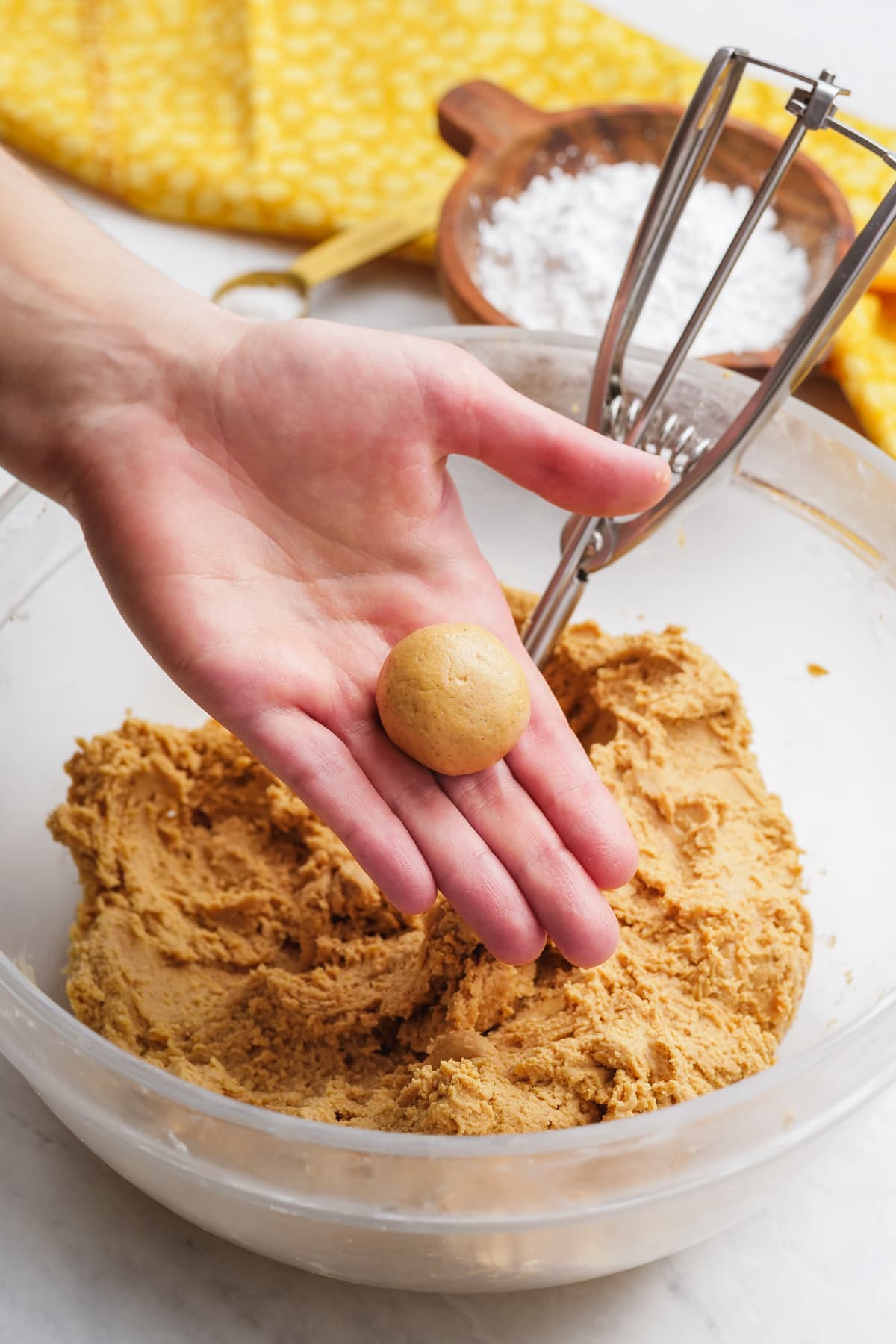 Woman's hand forms a ball of dough