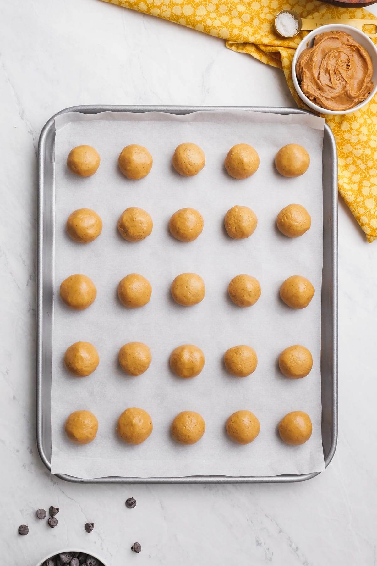 buckeye dough balls lined up on a baking sheet