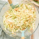 tossing together slaw sauce and coleslaw