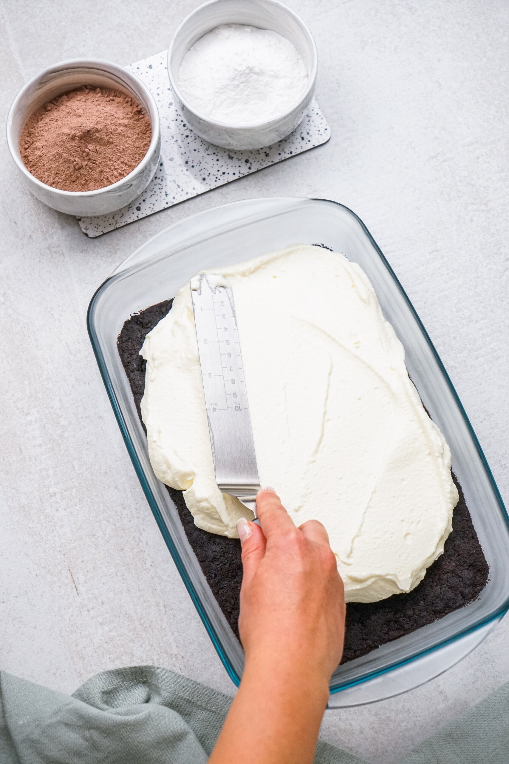 spatula spreading cream cheese/whipped cream mixture over crust